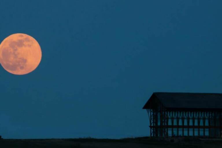 What causes the moon’s ash light to be dimmer than its glow?