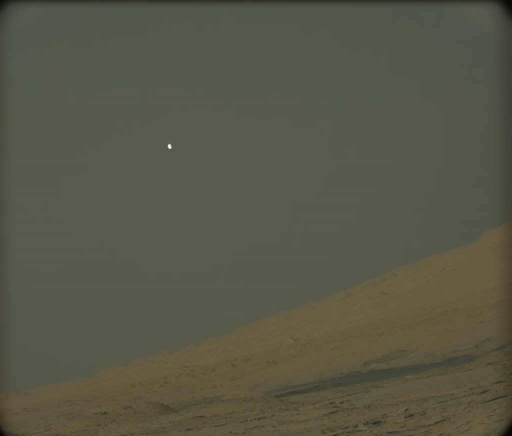 Phobos hides behind the spurs of Mount Sharp