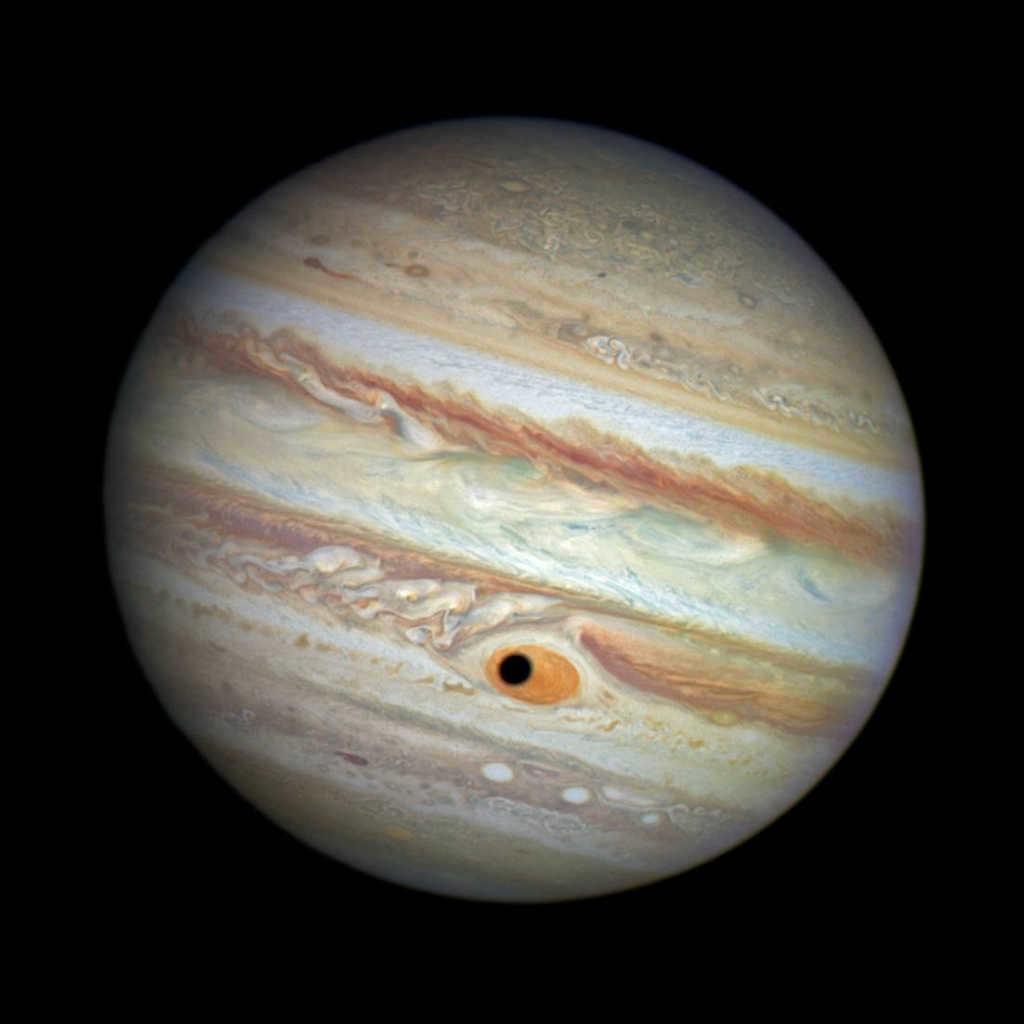 The shadow of Jupiter's satellite Ganymede passes over the Great Red Spot.