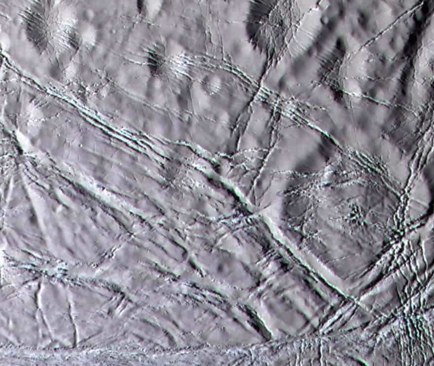 Color image of the moon's "snowy" landscape. The landscape is north of the geologically active south polar ridges. It is dotted with narrow fractures. 