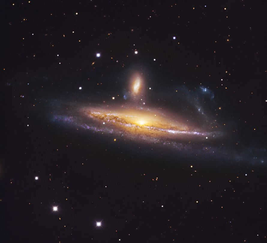 The galactic pair NGC 1531/2 is 70 million light-years distant in the southern part of the constellation Eridanus. NGC 1532 is the deformed spiral galaxy in the foreground. It is so close to its companion (with a bright nucleus and just above the center) that it is changing: one of the spiral branches has distorted, and plumes of dust and gas become visible outside the disk. Because of their interaction, a whole generation of massive stars (purple objects in the spiral arms) has appeared.