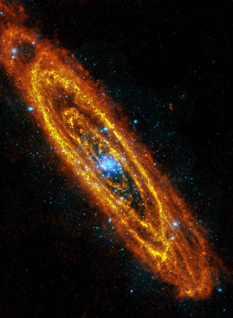 The explosive stars of M31 are shown here, along with numerous rings of cooler stars. The image compiles data from the Herschel Observatory in infrared light (orange) and the XMM-Newton telescope in X-rays (blue)