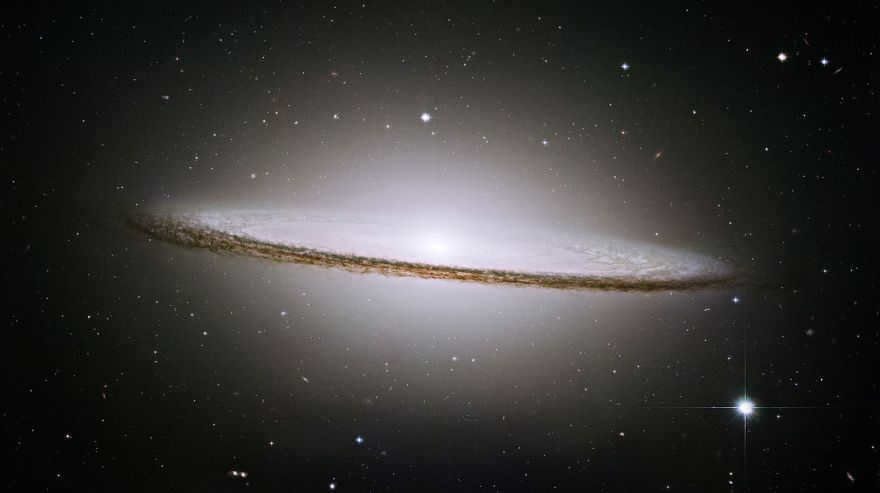 The famous Sombrero Galaxy (M104) is a bright nearby spiral galaxy. A prominent dust lane and a halo of stars and globular clusters give it an unusual shape. There is noticeable X-ray activity in the center. This feature and the high central velocities of the stars make many scientists think that a black hole, a billion times the solar mass, is hidden inside.