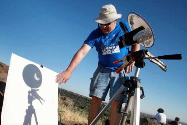 Joel Zdepski uses binoculars to show a solar eclipse