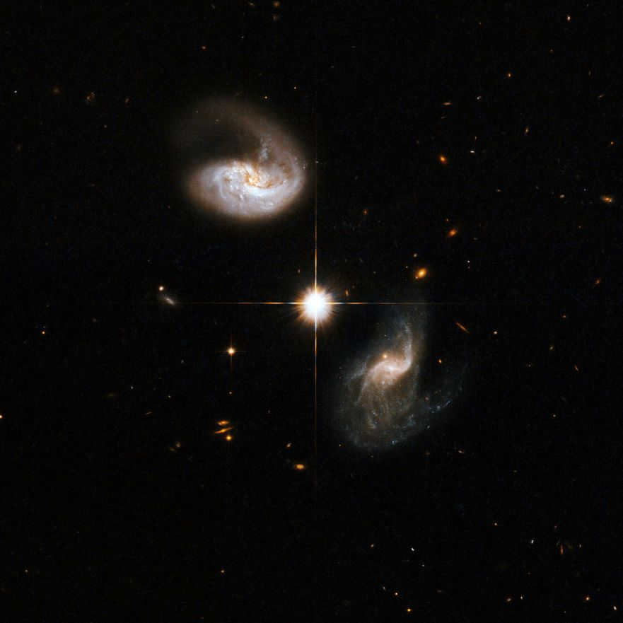 CGCG 436-030 is a spiral galaxy showing a distinct curly tail. The companion galaxy (bottom right) displays an entangled structure, including a number of tracks distant from the nucleus. The bright star (between them) does not belong to the interacting system and is located inside the Milky Way. This image is part of a huge collection of 59 images of galactic mergers captured by the Hubble Space Telescope.