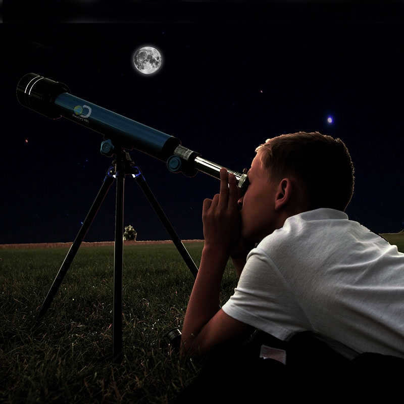 boy looking through a telescope