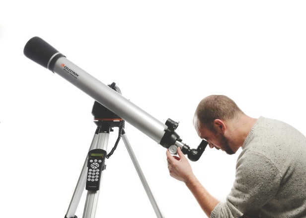 man looking through a telescope