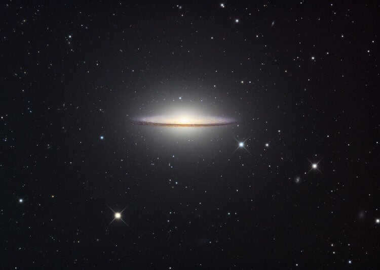 Sombrero Galaxy (M104). The Sombrero Galaxy is 29.3 million light-years away from the Sun. According to Spitzer observations, M104 is two galaxies: a flat spiral one is inside an elliptical one. Photo.