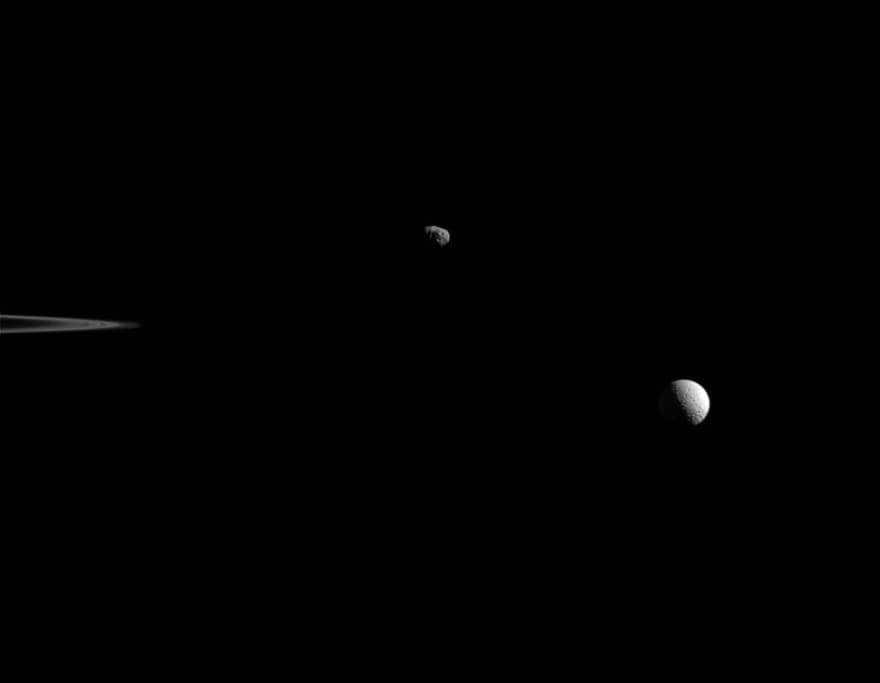 Janus and Mimas rotate in this view provided by the Cassini mission on October 27, 2015. The outer edge of Saturn's rings can be seen on the left. Janus is positioned above center and Mimas is on the right side. The irregular shape has caused Janus' terminator (the line separating day from night) to become jagged. At Mimas it is smooth, hinting at the spherical appearance of the moon. The green light of the instrument's narrow-angle camera was used for the image. The distance to Janus was 963000 km and the scale was 5.8 km per pixel. The distance to Mimas is 1.1 million km and the scale is 6.6 km per pixel. The Cassini program acts as a joint development of ESA, NASA and the Italian Space Agency. The team is based at the Jet Propulsion Laboratory. The two cameras on board are also built by them. The extracted photos are processed in Boulder, Colorado.