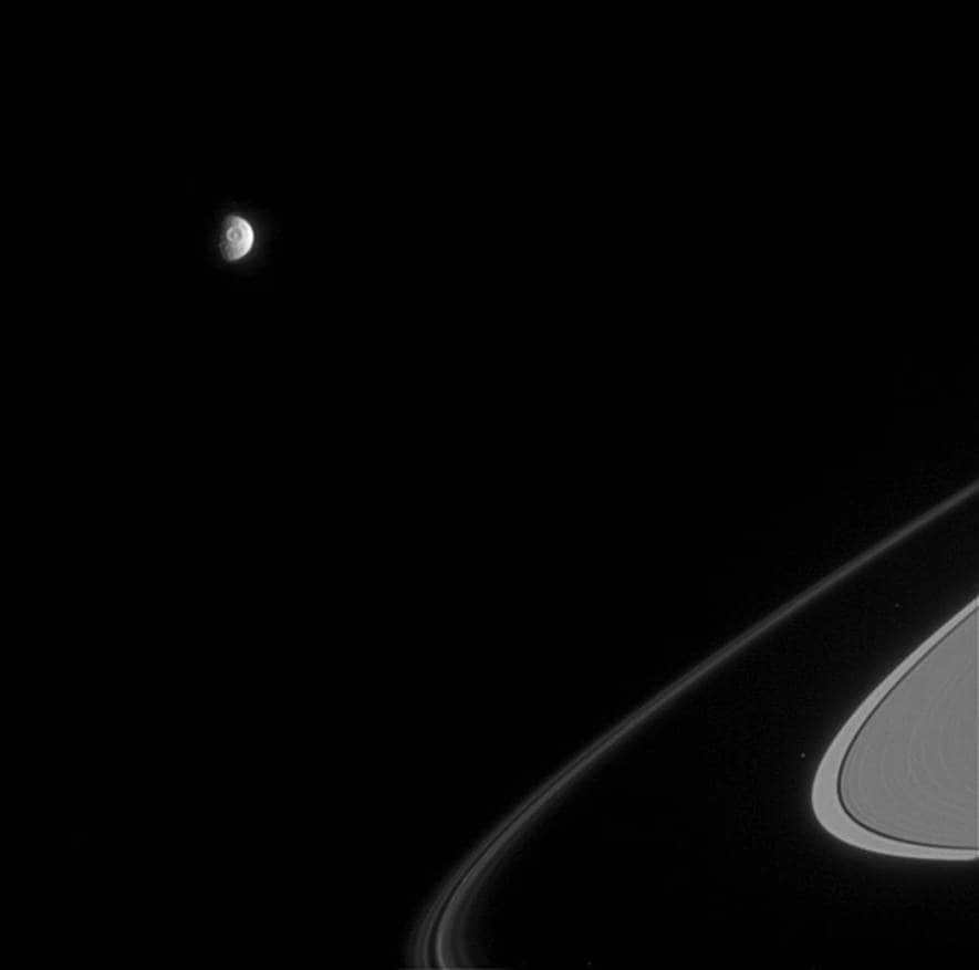 On April 5, 2005, Cassini positioned itself at a distance of 2.1 million km and at an angle of 72 degrees to capture the huge moon's eye, Mimas. This is the Herschel crater, which extends for 130 kilometers. Several arcs of the F-ring and a small part of Atlas are also noted in the image. Mimas spans 397 km in diameter and is turned toward the sunlight in the image. Atlas extends for 32 km. A narrow-angle camera with visible light was used for the view. The scale is 13 km per pixel. The Cassini program acts as a joint development of ESA, NASA and the Italian Space Agency. The team is housed at LRD. The two cameras on board are also built by them. The extracted photos are processed in Boulder, Colorado.
