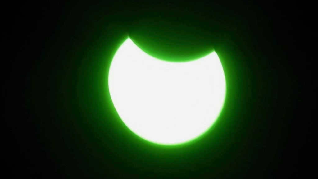 Observing a solar eclipse through a green light filter