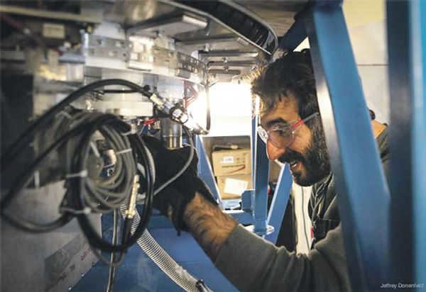 Graduate student Jonathan Kaufman replenishes the liquid helium needed for proper operation of the BICEP2 sensors that record the cosmic microwave background. Photo by Jeffrey Donenfeld from ucsdnews.ucsd.edu