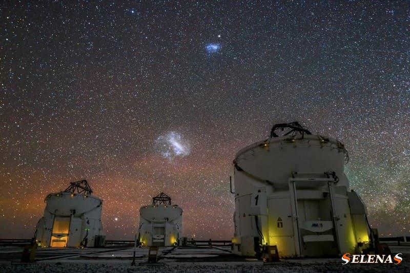 The Large and Small Magellanic Clouds are visible above the Very Large Telescope in the night sky over Chile.