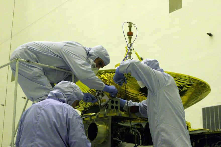 Engineers working on the instrument of the New Horizons spacecraft.