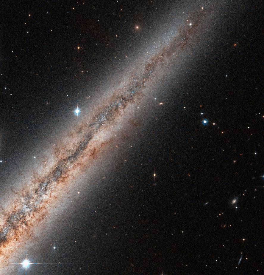 NGC891 was originally thought to look like the Milky Way when viewed from the side. But studies have shown the existence of fibers of dust and gas that have broken out of the plane of the galaxy into a halo hundreds of light-years away. They are clearly visible here against the bright background of the halo, expanding in space away from the disk. It is believed to be the result of ejected material due to supernovae or intense star formation activity.