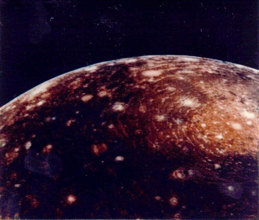 Voyager 1 image of Callisto from a distance of 350000 km. The huge "bull's eye" at the top is an impact basin that appeared early in the satellite's history. The bright center is 600 km wide and the outer ring is 2600 km wide. 